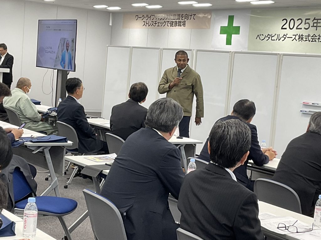 安全大会の講演講師として、マイクを手に安全とダイバーシティについて語るにしゃんたの講演シーン。